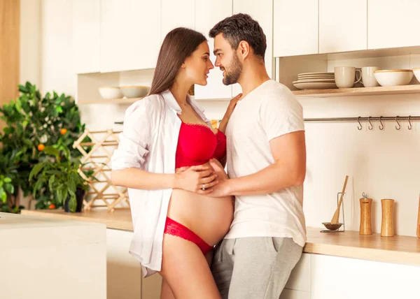 Casal grávida de pé em sua cozinha se preparando — Fotografia de Stock