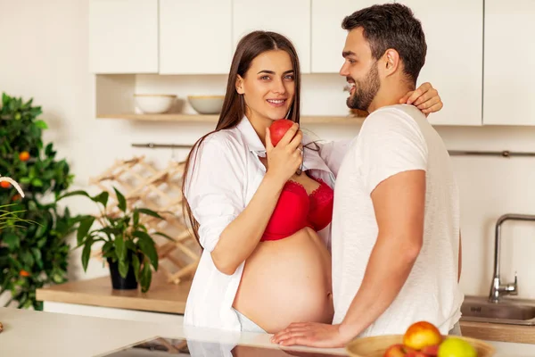 Casal grávida de pé em sua cozinha se preparando — Fotografia de Stock