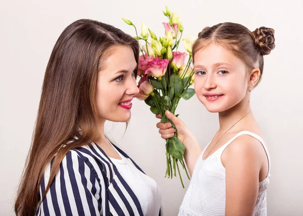 daughter gives flowers to her mother on her mother\'s day