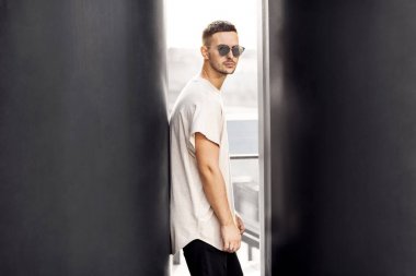 Hippi tarzı adam. Moda adam siyah duvara yakın ayakta