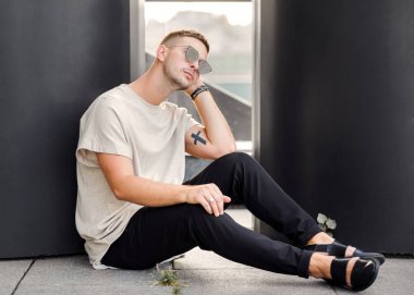 Hippi tarzı adam. Moda adam siyah duvara yakın ayakta