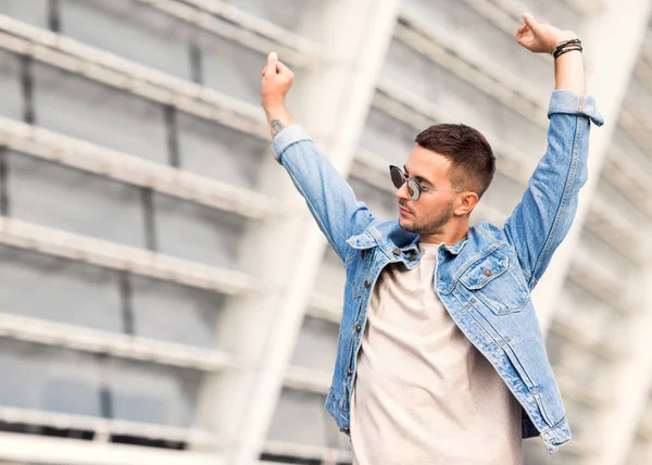 Gars de la mode posant dans les lunettes de soleil sur le coucher du soleil — Photo