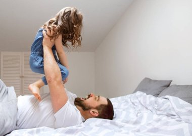 Baba ve kızı evde yatakta iyi eğlenceler. Babalar günü.