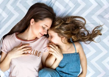 Anne ve kızı yukarıdan görünüm onların gözleri kapanıyor. Anneler günü.