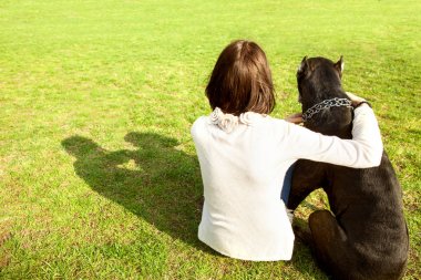 Kız parkta büyük köpeğiyle Cane Corso, dikiz oturur