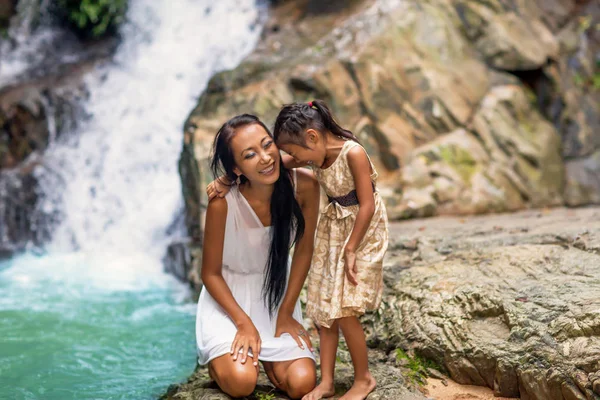 Mãe feliz com sua filha nos trópicos perto da cachoeira. Dia das mães . — Fotografia de Stock