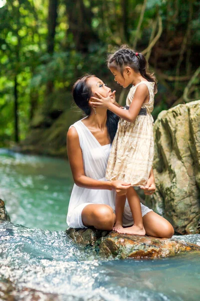 Asiática mãe feliz com sua filha nos trópicos perto da cachoeira. Dia das mães . — Fotografia de Stock