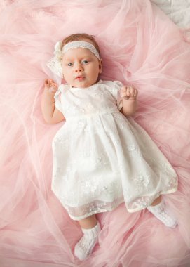 Bebek pembe elbise yatakta yatıyor