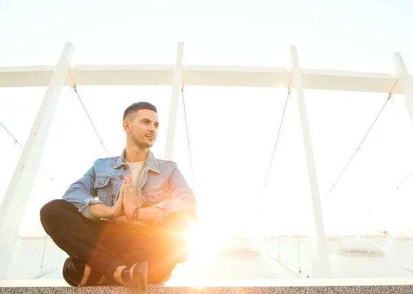 Ragazzo della moda seduto al tramonto in posa in foto — Foto Stock