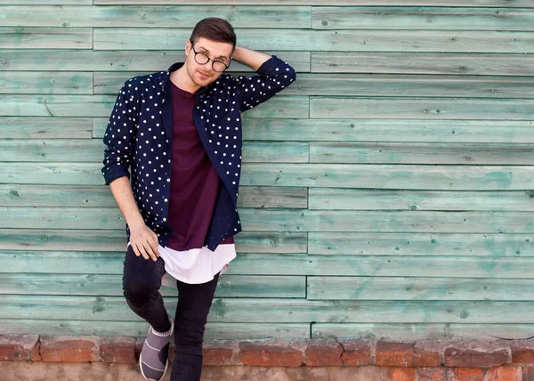 Moda cara hipster em óculos de moda posando em um backgroun azul de madeira — Fotografia de Stock