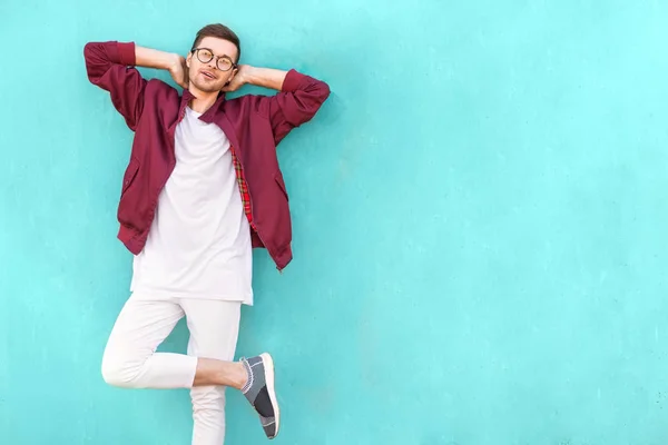 Fashion guy in glasses poses near the wall the color of the sour wave — Stock Photo, Image