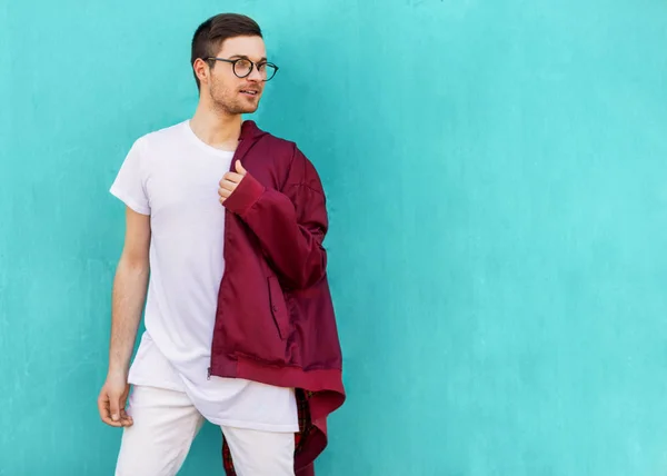 Cara de moda em óculos posa perto da parede a cor da onda azeda — Fotografia de Stock