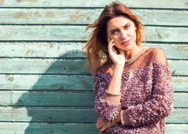 Moda ragazza posa vicino a un muro di legno turchese — Foto Stock