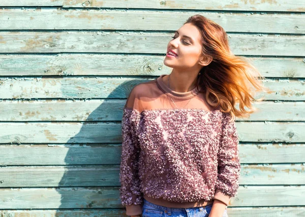 Chica de moda posando cerca de una pared de madera turquesa — Foto de Stock