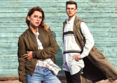 Mavi ahşap duvar üzerinde poz yeşil giysili moda çift gözlük ile gözlük