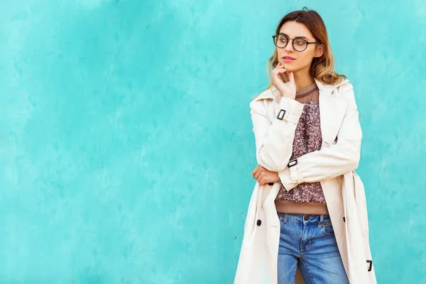 Mode flicka i runda glasögon står posing nära en turkos wal — Stockfoto