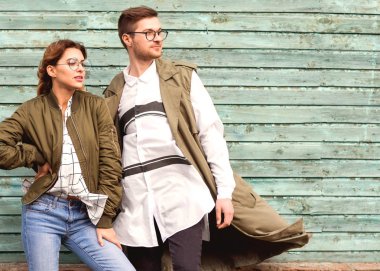 Mavi ahşap duvar üzerinde poz yeşil giysili moda çift gözlük ile gözlük