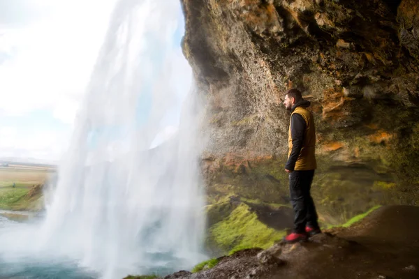 景色を楽しみながら滝の近くに立っている男の観光 — ストック写真