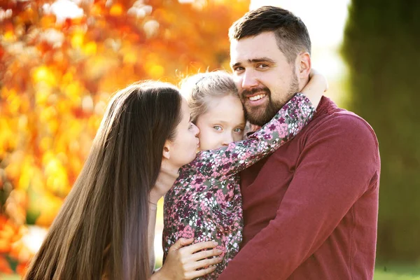 Family with daughter walks in autumn park — Stock Photo, Image