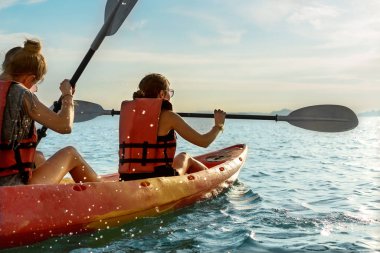 Birkaç kız arkadaş gün batımında Tayland 'da kayak yapıyor.