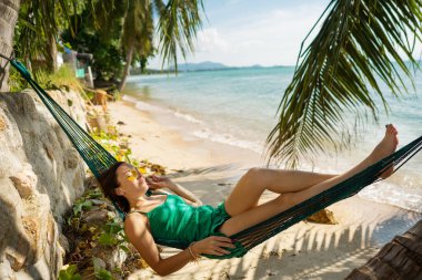 girl lies in a hammock by the sea in Thailand