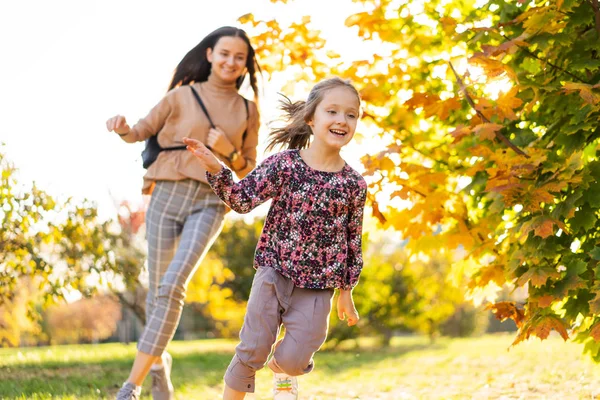 Familie in het park met dochter bij zonsondergang — Stockfoto