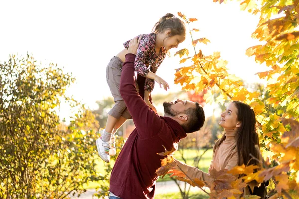 Âşık bir aile gün batımında sonbahar parkında oynuyor. — Stok fotoğraf