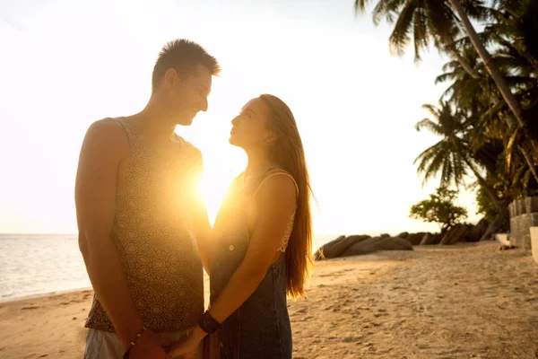 Casal apaixonado ao pôr do sol junto ao mar, dia dos namorados — Fotografia de Stock