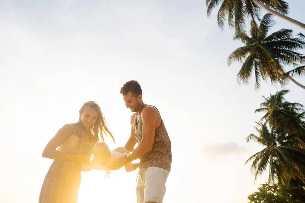 Família feliz caminhar ao longo de uma praia tropical ao pôr do sol — Fotografia de Stock