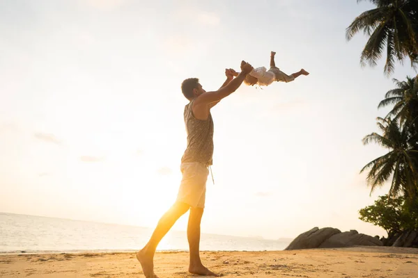 Papá con un niño al atardecer en la playa divirtiéndose y girando —  Fotos de Stock