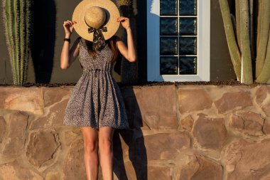 Kaktüsler arasındaki şapkalı moda kızı.