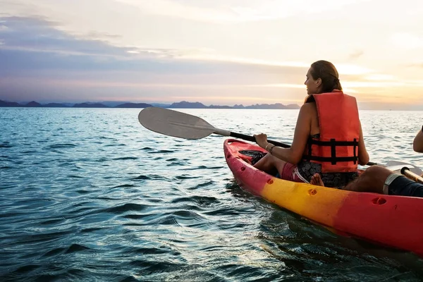 Faire du kayak ensemble. Beau jeune couple kayak sur le lac ensemble et souriant au coucher du soleil — Photo