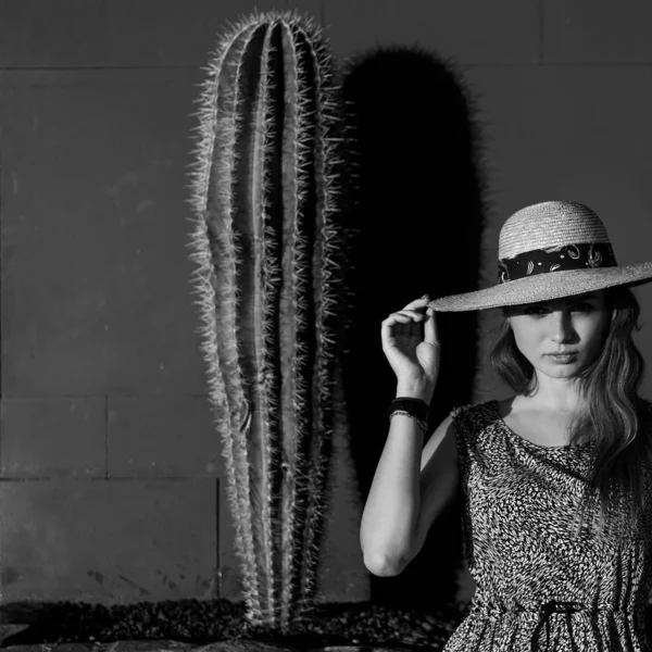 Fashion girl among cacti in a hat — Stock Photo, Image