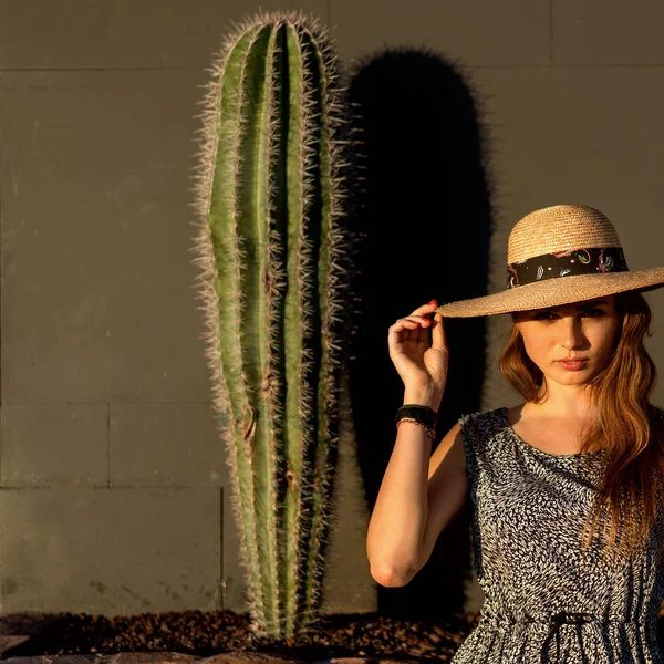 Fashion girl among cacti in a hat — Stock Photo, Image