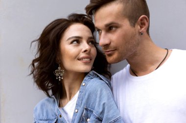 Gri arka planda poz veren moda çifti