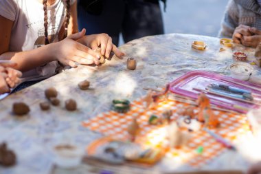 Çocuklar çömlekçilikten kil figürler yapar