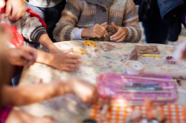 Çocuklar çömlekçilikten kil figürler yapar