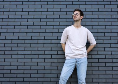 Moda adamı koşar ve tuğla renkli şehir geçmişi pozu verir.