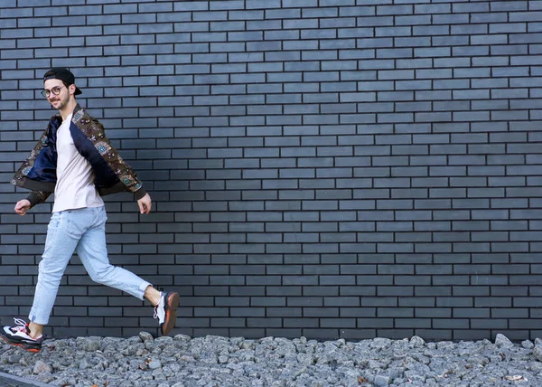 Modemann Rennt Und Posiert Vor Ziegelschwarzem Urbanem Hintergrund — Stockfoto