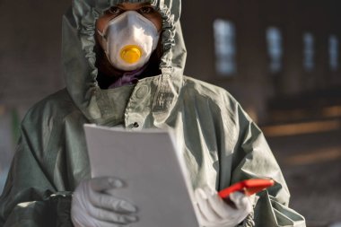 Koronavirüse karşı koruyucu maske takan doktor. Personel önleyici ekipman. Evinde elinde bir poster tutarken