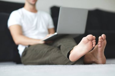 Dizüstü bilgisayarı ve köpeği olan serbest çalışan bir adam karantinada Coronavirus enfeksiyonu için çalışıyor.