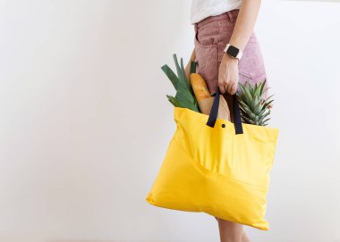 Evde paket yiyecek dolu bir çanta tutan bir kız. Yemek teslimatı