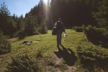 Yürüyüşçü gün batımı yürüyüşünde dağlara gider. Eko-izm.