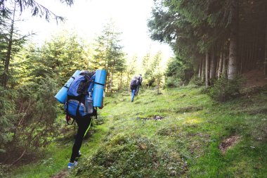 Yürüyüşçüler gün batımı yürüyüşünde dağlara gider. Eko-izm.