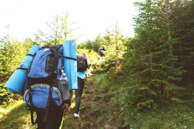 Yürüyüşçüler gün batımı yürüyüşünde dağlara gider. Eko-izm.