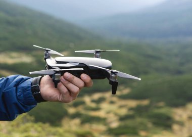 Adam dağlarda drone tutan bir turist.