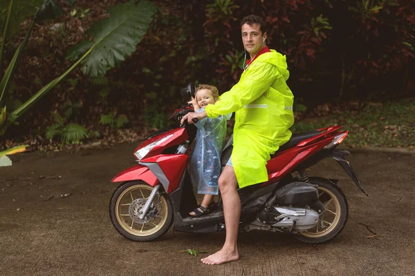 爸爸和他的儿子骑摩托车在热带棕榈树中成长 — 图库照片
