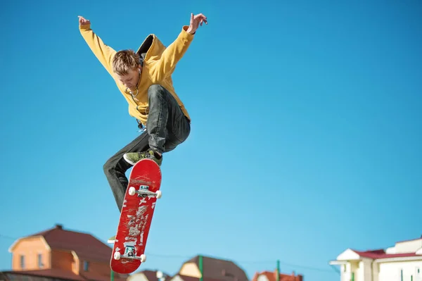Um skatista adolescente faz um truque ollie em um parque de skate nos arredores da cidade — Fotografia de Stock