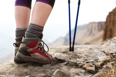 Trekking botları Nordic walking kayalar ve uzak Kafkas topraklarda arka planı için sopa ile kadın bacakları Close-Up