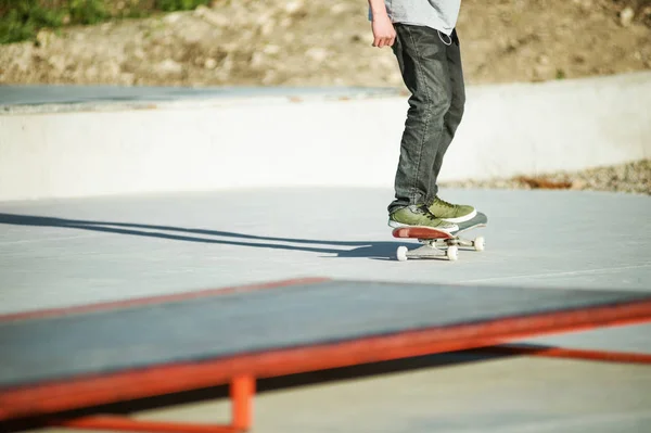 Deskorolka nogi skaterzy zbliżenie na beton. Jazda na deskorolce młodzieży popularne sporty ekstremalne — Zdjęcie stockowe